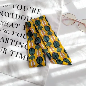 Vue détaillée du foulard en coton imprimé jaune, idéal pour les sacs et le cou.