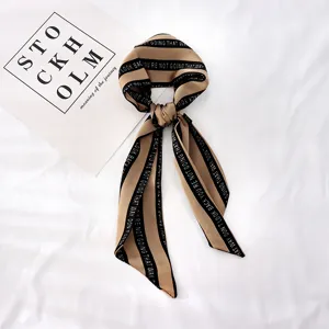 Vue détaillée de l'écharpe ruban pour cheveux longue rayée avec impression de texte, accessoire.