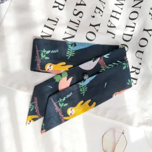 Vue détaillée du foulard étroit en coton avec motif de paresseux, élégant ruban.