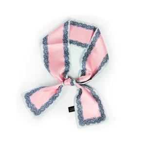Foulard étroit en soie rose avec bordure vintage bleue, élégamment noué pour sac à main ou cou.