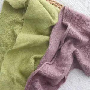 Détail d'un châle triangulaire en tricot doux montrant une texture fine pour l'automne.