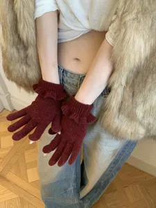 Burgundy knit gloves for women featuring a cute ruffle cuff, soft warm winter accessory.