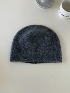 Berretto in maglia grigio scuro, consistenza morbida in lana, dettaglio cappello caldo invernale.