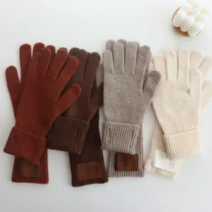 Vue détaillée de gants longs en laine tricotée pour femme avec étiquette, chauds pour hiver.