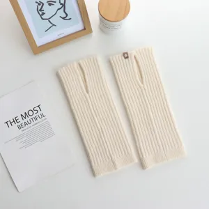 Beige geribbelde beenwarmers met split, minimalistisch gebreid accessoire detail.