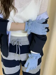 Detail shot of women's winter knit gloves with cute ruffle trim, soft warm blue fabric.