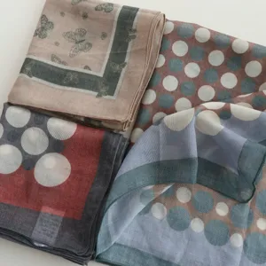 Detailed shot of 55cm cotton square scarf featuring elegant polka dots and butterfly patterns.