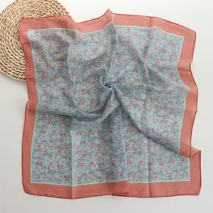 Close-up detail of the vintage floral cotton square scarf showing soft fabric texture.