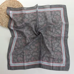 Close-up detail of the retro paisley patterned cotton square scarf in dark grey with borders.