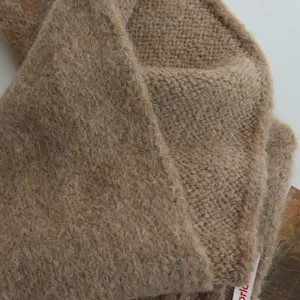 Vue détaillée de la texture douce et confortable de l'écharpe en tricot uni, chaleureux.