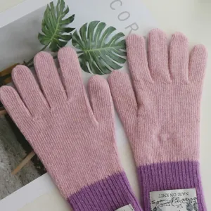 Detailed view of colorblock knit winter gloves, cozy pink and purple design for cold weather.