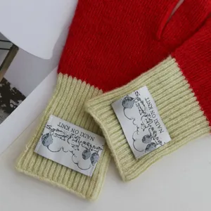 Close-up detail of stylish knit gloves featuring vibrant color blocking and woven label.