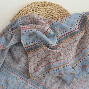 Close-up of blue paisley floral scarf, lightweight soft fabric texture detail view.