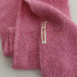 Gros plan écharpe d'hiver en mohair tricoté rose, texture douce et douillette, col chaud.