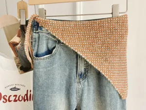 Korean style knitted waist wrap triangular scarf paired with classic denim jeans for women.