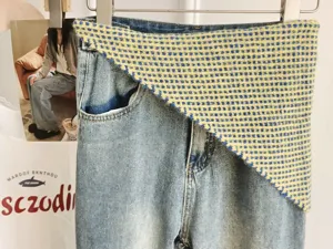 Trendy women denim pants with blue yellow plaid knit layered triangular waist scarf.