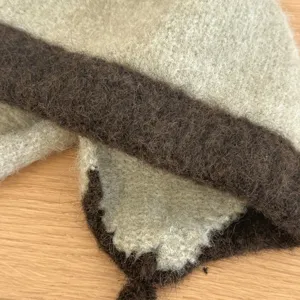 Vista detallada del gorro trampero de peluche, tejido de punto cálido y suave con orejeras y lazos.