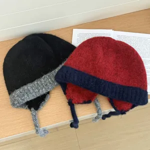 Vista detallada del gorro de punto de felpa de invierno con orejeras y cordones trenzados.