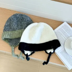 Primer plano detallado de cómodos gorros de felpa tejida con orejeras para invierno.