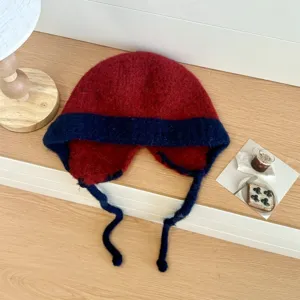 Detalle de gorro ruso de punto rojo y azul, gorro de invierno cálido de felpa con orejeras.