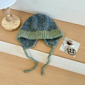 Primer plano detallado del acogedor gorro de punto mullido con orejeras para invierno.