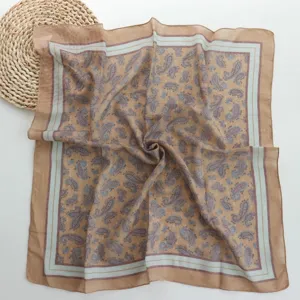 Detail view of a vintage paisley cotton square scarf, soft texture, elegant floral design.