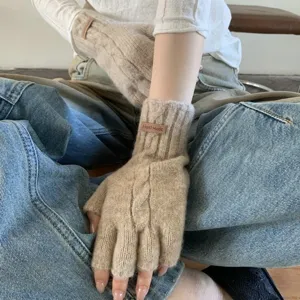 Knit fingerless gloves detail view, featuring cozy beige woolen material with a chic leather tag.