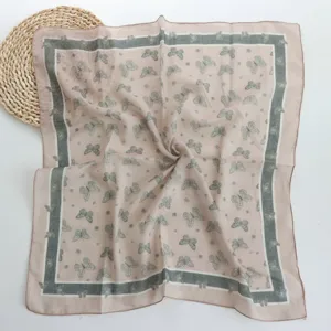 Close-up of the 55cm square scarf showing elegant butterfly print and chic color block border.