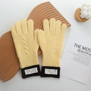 Close-up detail of stylish color-block knitted gloves in warm yellow and brown winter wear.