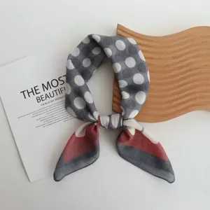 Detail view of cotton polka dot square scarf with color block design, stylish neck accessory.
