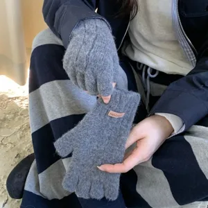 Close-up detail of grey knitted fingerless gloves for women winter wear, cozy knit texture.