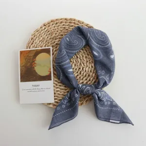 Close-up of a stylish grey paisley square scarf, perfect for chic spring and summer styling.