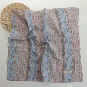 Detailed view of women blue floral paisley square scarf, elegant retro pattern neckerchief.