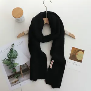 Vue détaillée d'une écharpe d'hiver noire et douillette, texture douce, accessoire chic.
