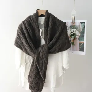 Close-up detail of dark brown cable knit shawl scarf, cozy textured winter woolen wear.