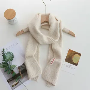 Écharpe tricotée douce en beige crème uni, long chauffe-cou confortable vue de détail.