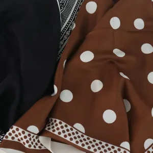 Nahaufnahme des Stoffdetails mit braunem Polka-Dot- und schwarzem Paisley-Muster.
