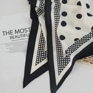 Nahaufnahme eines eleganten schwarz-weißen Pünktchen-Schals mit stilvollem Polka-Dot-Muster.