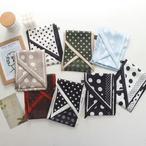 Detail view of stylish long silk scarves featuring classic polka dot and paisley patterns.