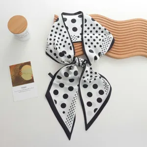 Detailed view of a chic black and white polka dot silk ribbon scarf featuring elegant borders.