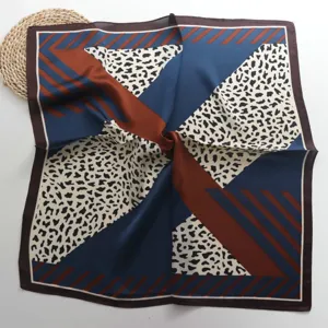 Gedetailleerd overzicht van de satijnen sjaal met geometrische en luipaardprint.