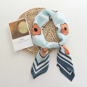 Gedetailleerd uitzicht van de blauwe satijnen sjaal met elegante oranje bloemenprint en mooie strepen.