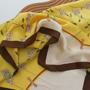 Detailansicht des blumigen Seidenquadratstuchs für Damen, gelb und braun elegantes Design.