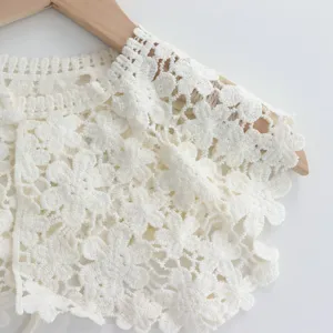 Detail view of white crochet lace hollow shawl false collar, delicate floral pattern design.