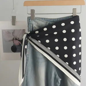 Schicker schwarz-weißer Pünktchen-Seidenschal kombiniert mit Jeans für stylische Outfits.