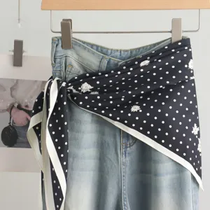 Elegant navy blue polka dot silk triangle scarf paired with classic denim jeans display.