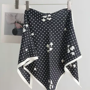 Dark blue polka dot silk scarf detail showing elegant floral print and crisp white borders.