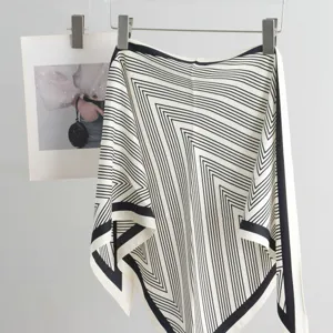 Detailed view of the black and white striped triangle silk scarf hanging gracefully on display.