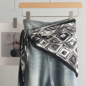 Stylish geometric pattern silk triangle scarf paired with denim jeans fashion accessory.