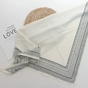 Elegant ivory white square scarf with classic black paisley border, chic and stylish.